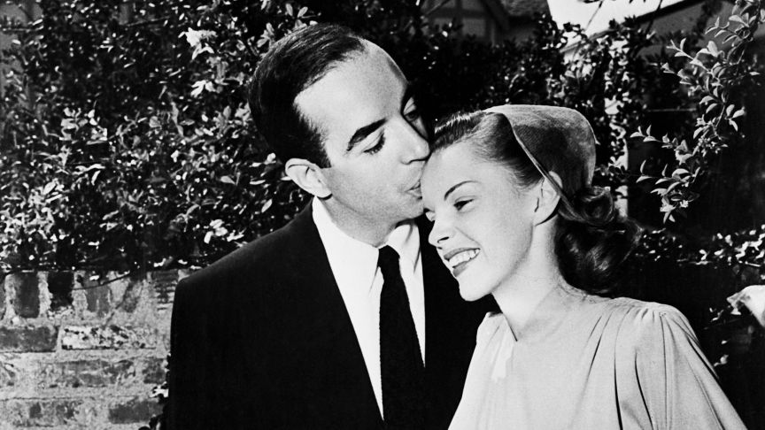 1945: Film director Vincente Minnelli (1903 - 1986) kisses singer and actress Judy Garland (1922 - 1969) on the brow at their wedding