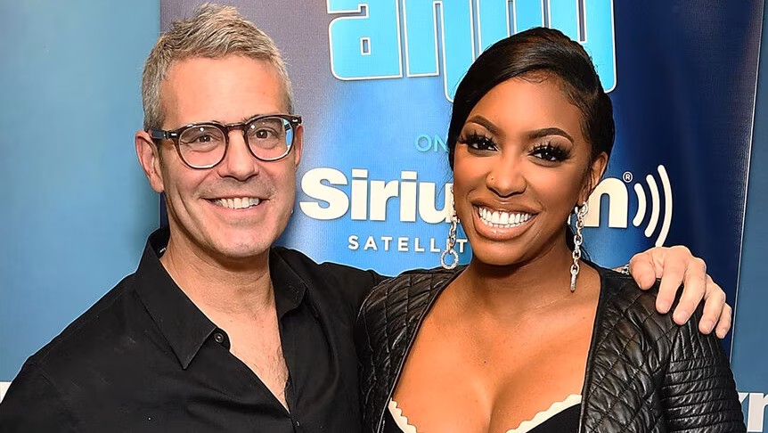 Andy Cohen smiles alongside Porsha Williams during a promotional appearance before the "The Real Housewives of Atlanta" Season 17 reunion.