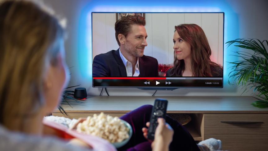 woman watching a Hallmark movie with Andrew Walker and Lacey Chabert