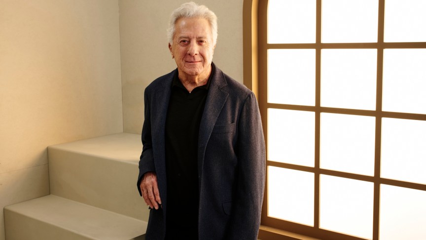 Dustin Hoffman poses in a black shirt and suit.