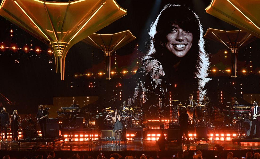 US singer Olivia Rodrigo performs under a photo of Carly Simon, on stage during the 37th Annual Rock and Roll Hall of Fame Induction Ceremony