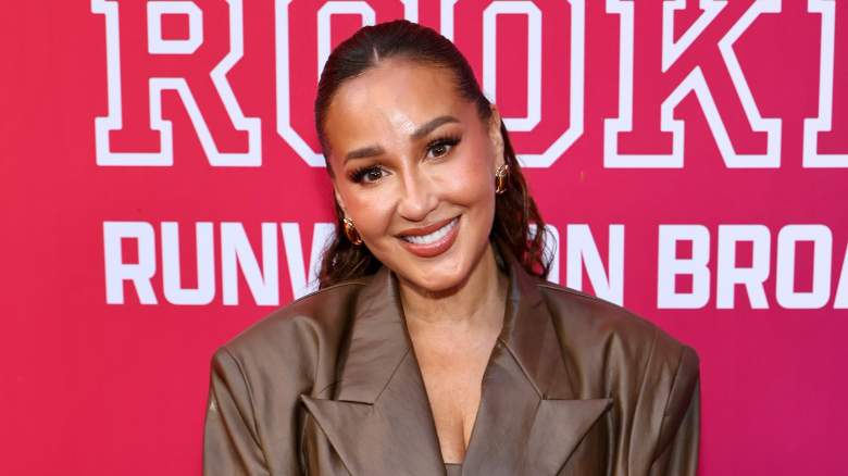 Adrienne Bailon smiling on the red carpet.