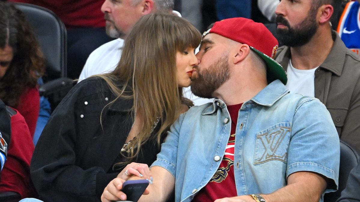 Singer Taylor Swift and Travis Kelce of the Kansas City Chiefs kiss during Game Three between the New York Knicks and the Cleveland Cavaliers in the NBA Eastern Conference Finals at Rocket Arena.