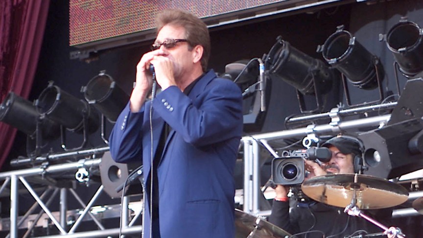 Huey Lewis performing in concert.