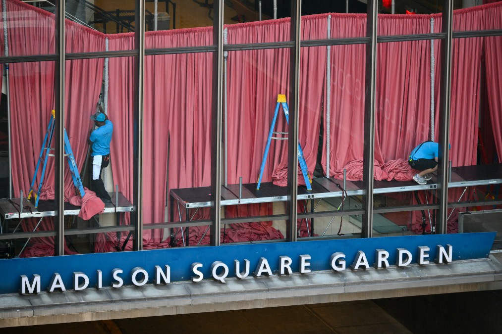Workers adjust curtains inside Madison Square Garden