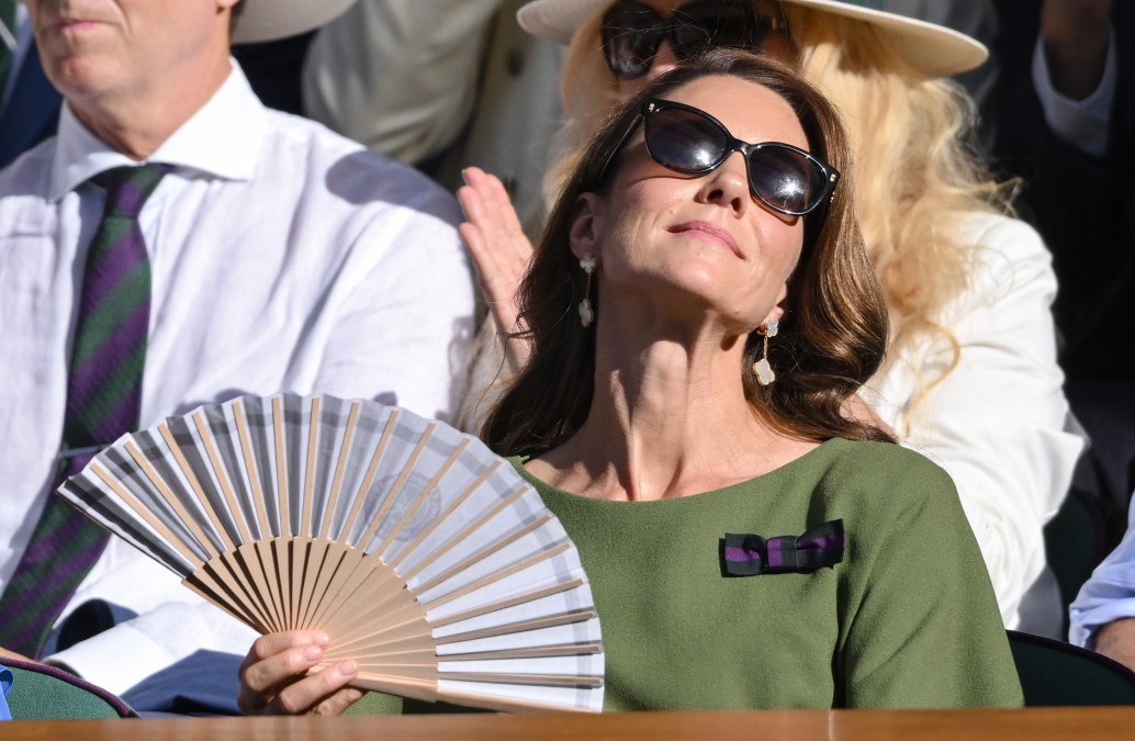 Catherine, Princess of Wales cools down with a fan as she attends day fourteen of the 2026 Wimbledon Tennis Championships 
