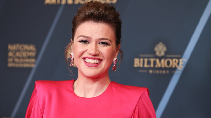 Kelly Clarkson smiles in a red dress.