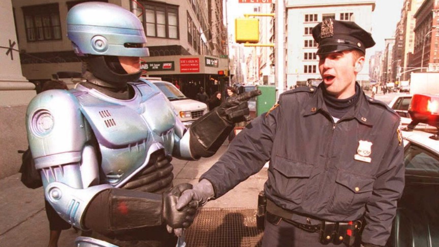 New York City Police Officer Paul Dean gets a handshake from a person dressed as "RoboCop."