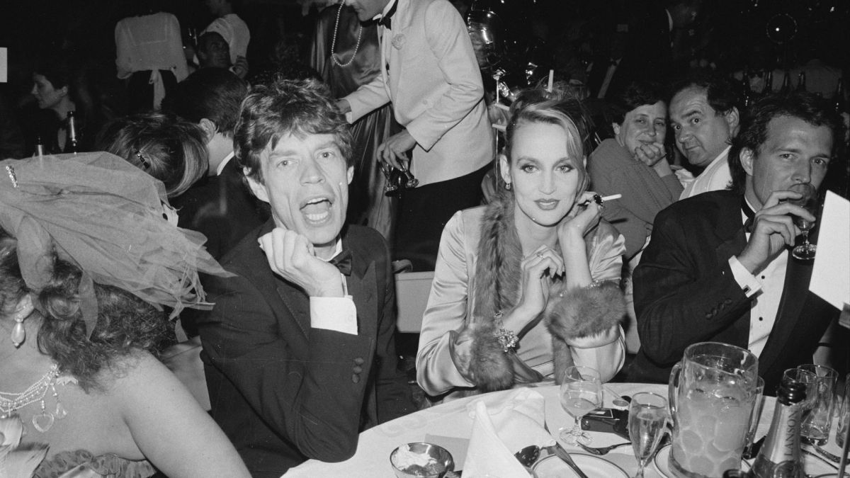 English singer, songwriter, actor, and film producer Mick Jagger and American model and actress Jerry Hall attend the Berkeley Square Ball, London, UK, in 1984.