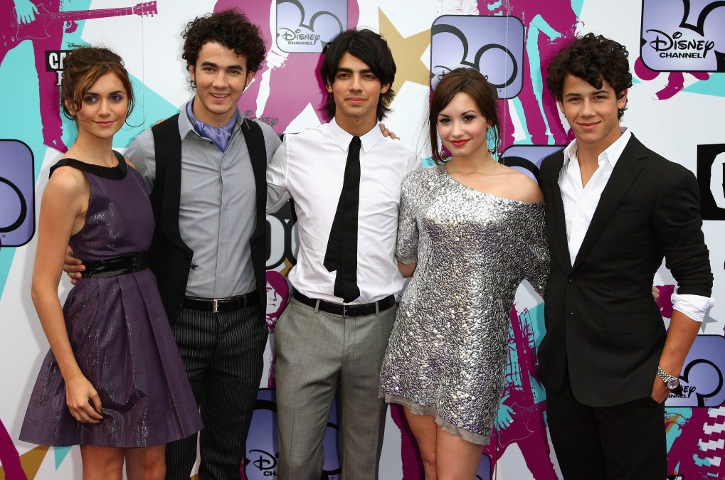 A photo of some cast-members of "Camp Rock" posing on a Disney red carpet.