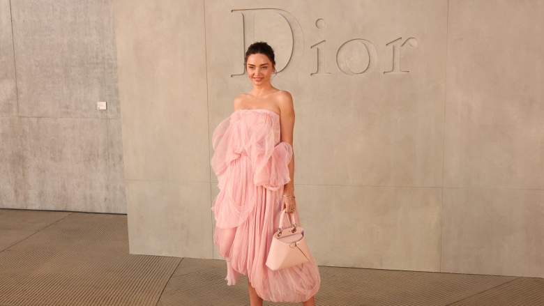 Miranda Kerr poses at Dior in a peach color dress